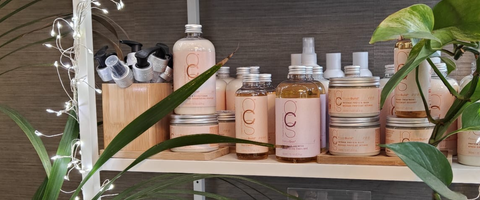 Organic Colour Systems hair care displayed up on a retail shelf with plants around it